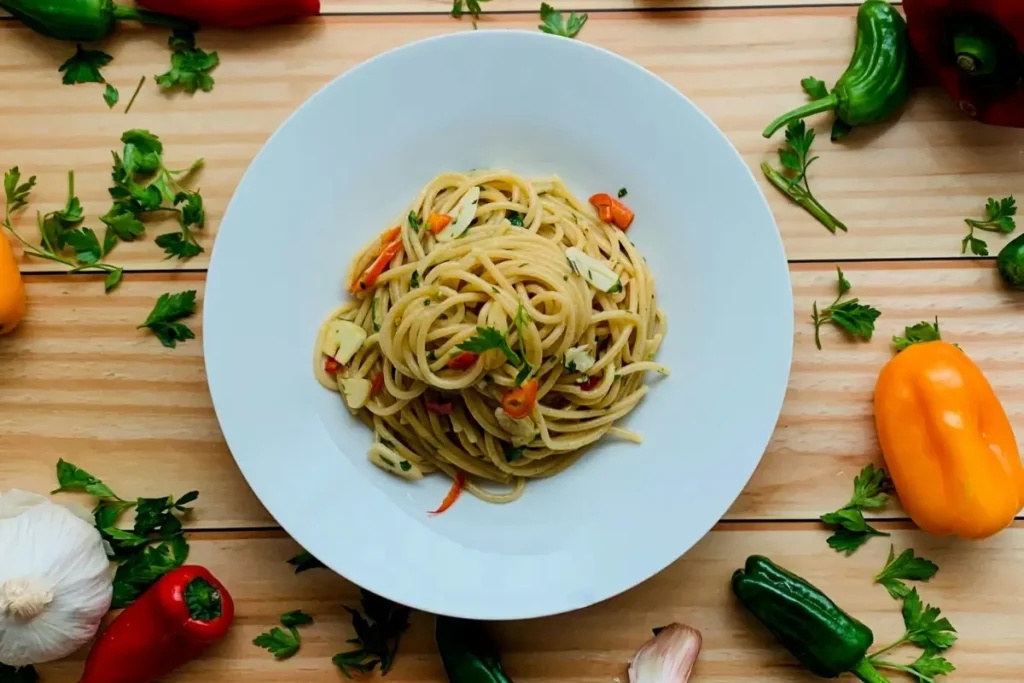 A bowl of lemon ricotta pasta with lemon zest and herbs on top.